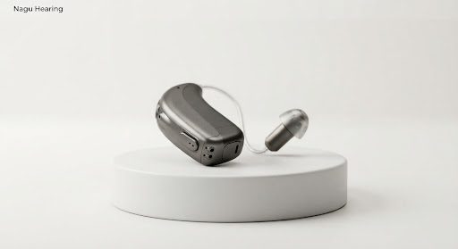 High-end studio product photo of Oticon Intent hearing aid in sleek charcoal titanium tone showcasing miniature sensor micro-housing on clean white clinical podium.