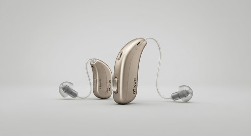 Studio catalog shot of the Oticon Real hearing aid device in champagne gold color highlighting ergonomic curves and discreet micro-receivers on neutral light grey backdrop.